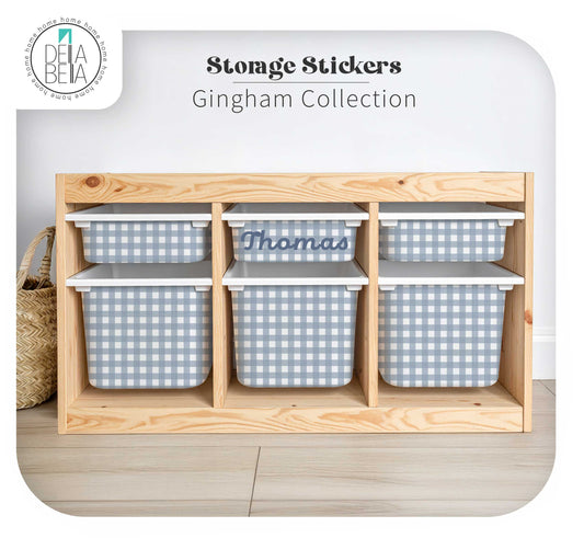 Six gingham storage bins arranged in a wooden organizer shelf, with three bins featuring light blue and white gingham patterns and one custom bin labeled 'Thomas'. The image includes text overlays reading 'Storage Stickers Gingham Collection' and a Delal Bella logo in the top left corner.
