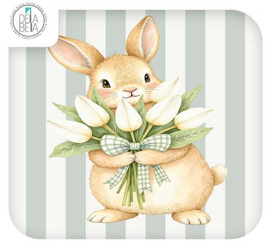 Ikea trofast sticker of a beige rabbit holding white tulips with a green-and-white checkered bow, set against a pale green and white striped background. A Dela Beba logo appears in the top-left corner.