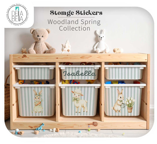 A ikea trofast custom stickers wooden storage unit with six striped fabric bins decorated with woodland spring-themed stickers, including bunnies, a lamb, and flowers. The bins are arranged on a light wood shelf with a teddy bear and stuffed animals on top.